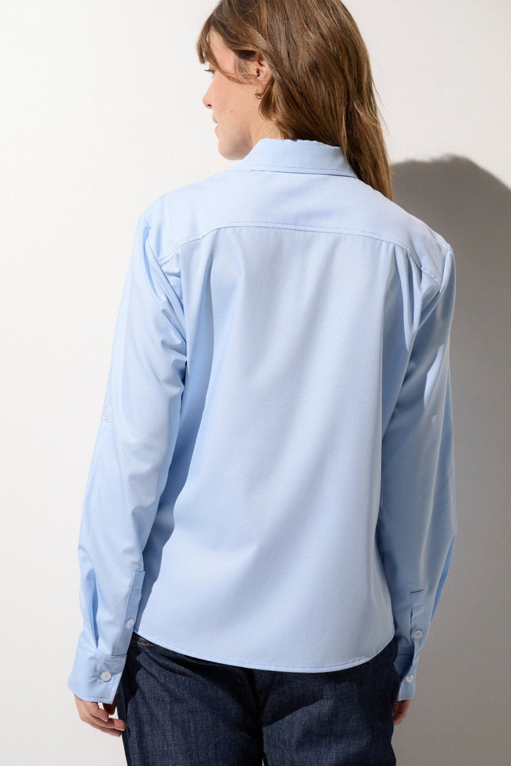 Chemise anti-UV bleue UPF50+ pour femme, avec col relevable pour une protection solaire élégante.