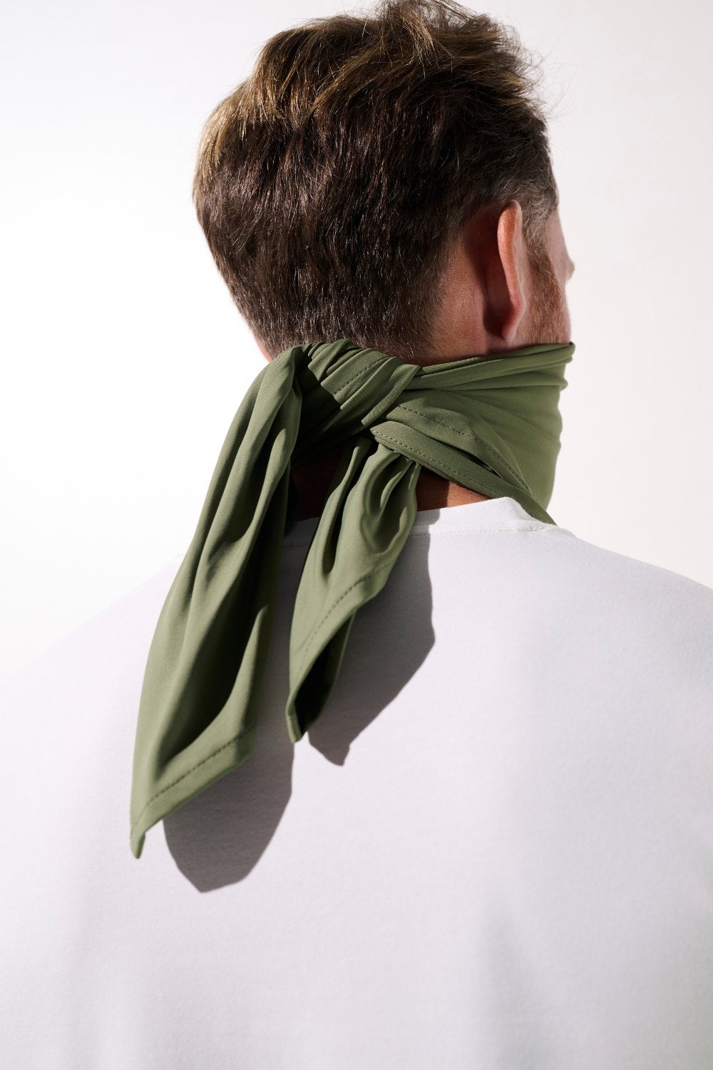 Bandana anti-UV vert olive UPF 50+, porté par un homme pour une protection solaire lors d'activités extérieures.