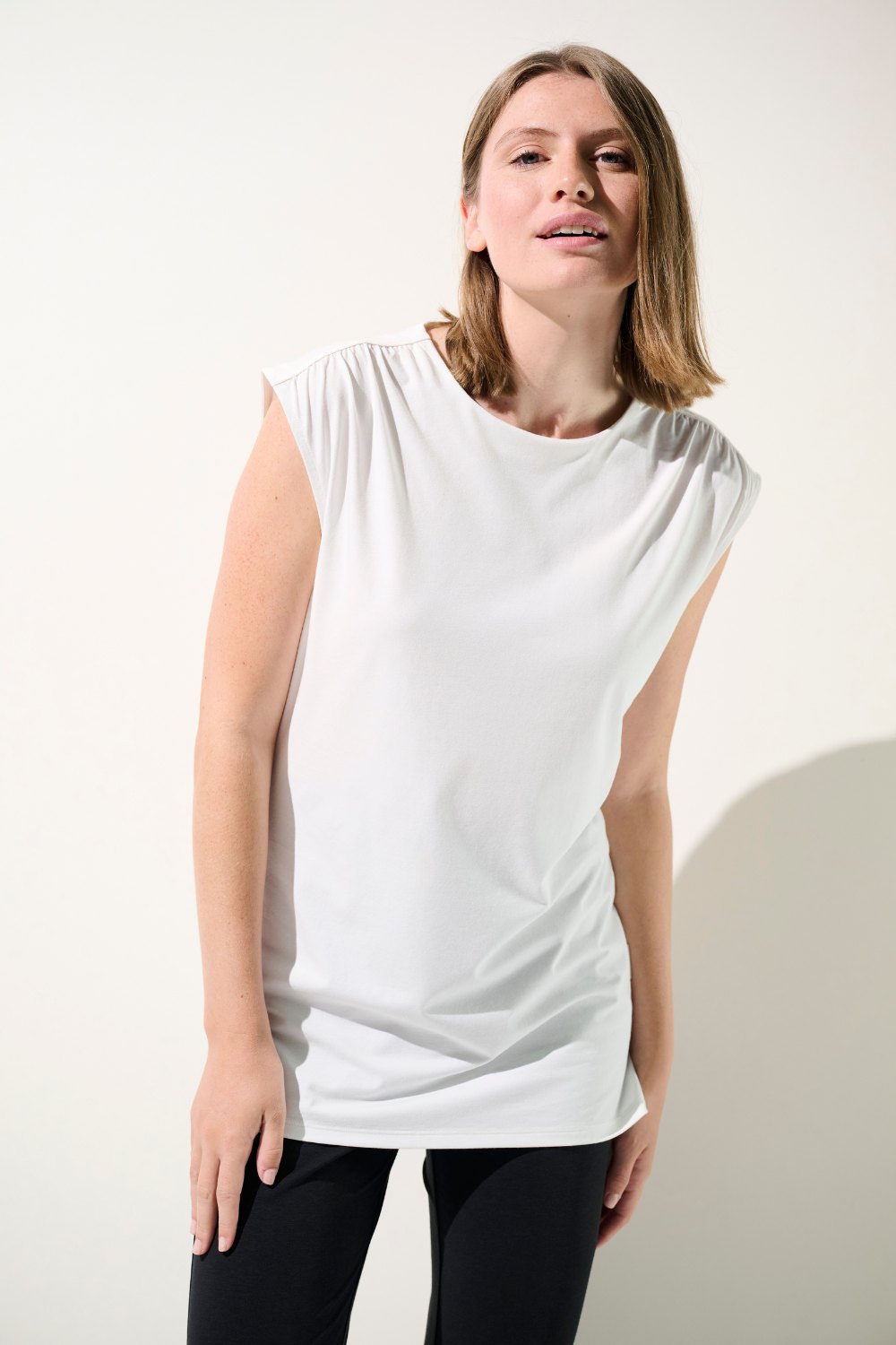 Débardeur anti-UV blanc UPF 50+ pour femme, élégant et décontracté, idéal pour une protection solaire quotidienne.