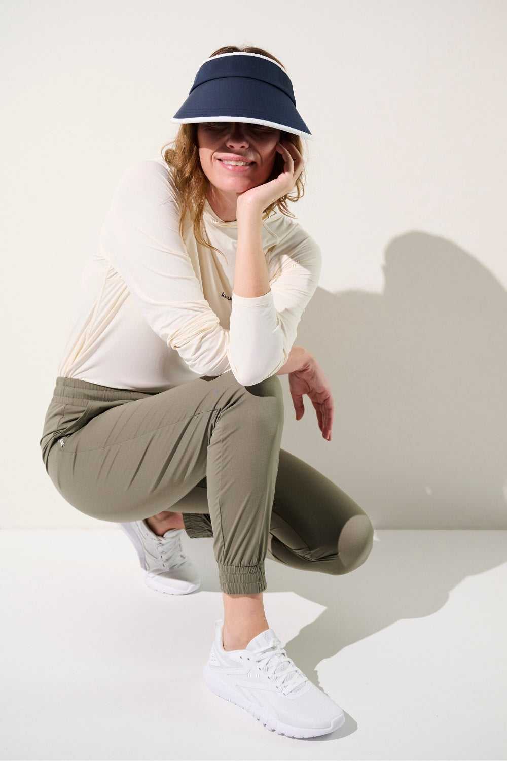 Femme portant un pantalon anti-UV - Oasis, chic et léger, UPF 50+, parfait pour des sorties actives au soleil.