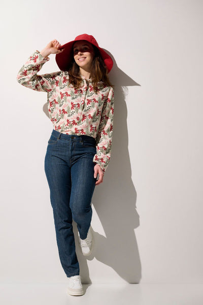 Femme portant une blouse anti-UV - Positano colorée avec chapeau, idéale pour la protection solaire.
