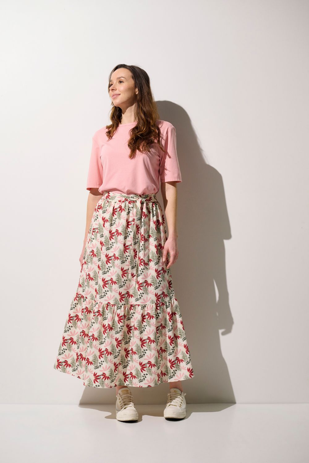 Jupe anti-UV - Positano, longue et élégante avec motif floral, portée par une femme avec un t-shirt rose.