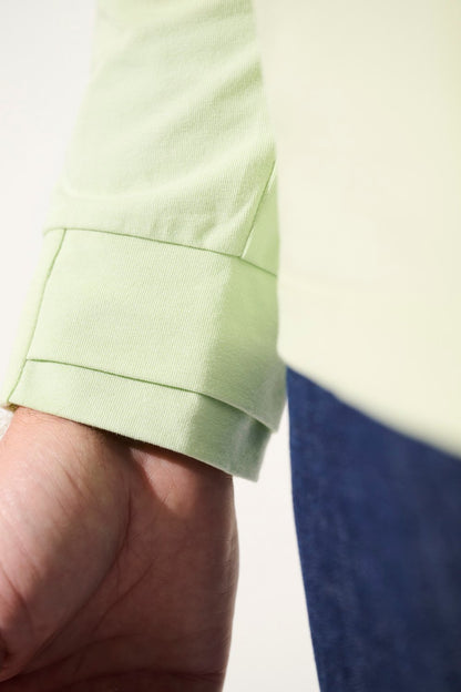 Manche d'un polo anti-UV vert clair UPF 50+, confortable et élégant pour les sorties au grand air.