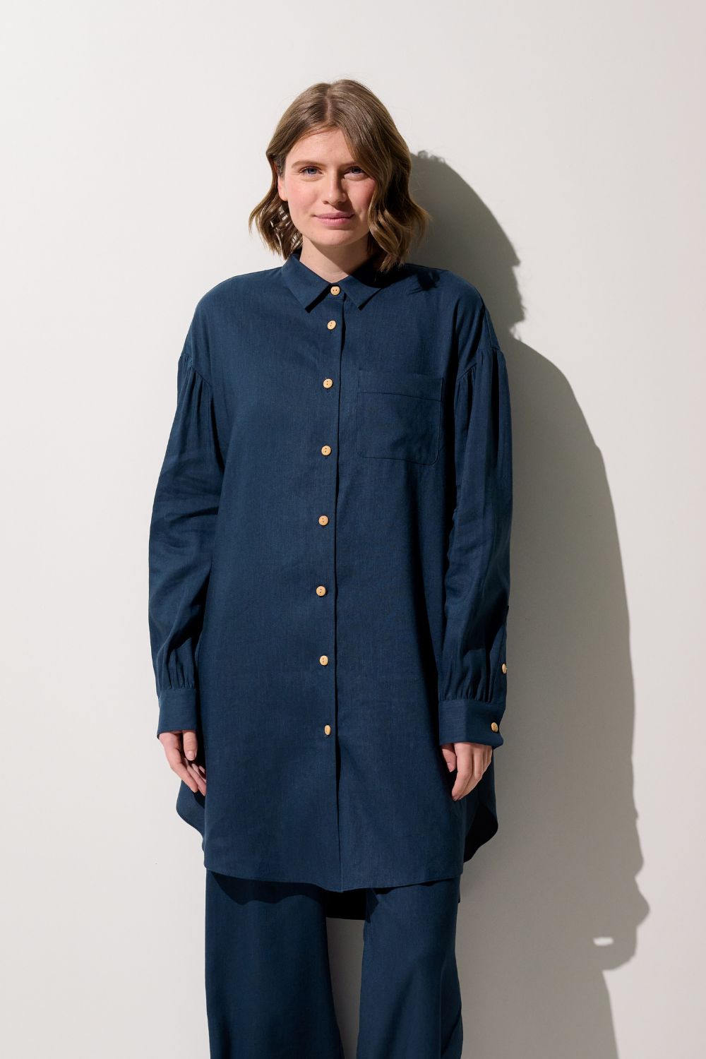 Chemise longue anti-UV - Sylt, femme portant une chemise bleu marine, légère et chic, UPF 50+ pour protéger du soleil.
