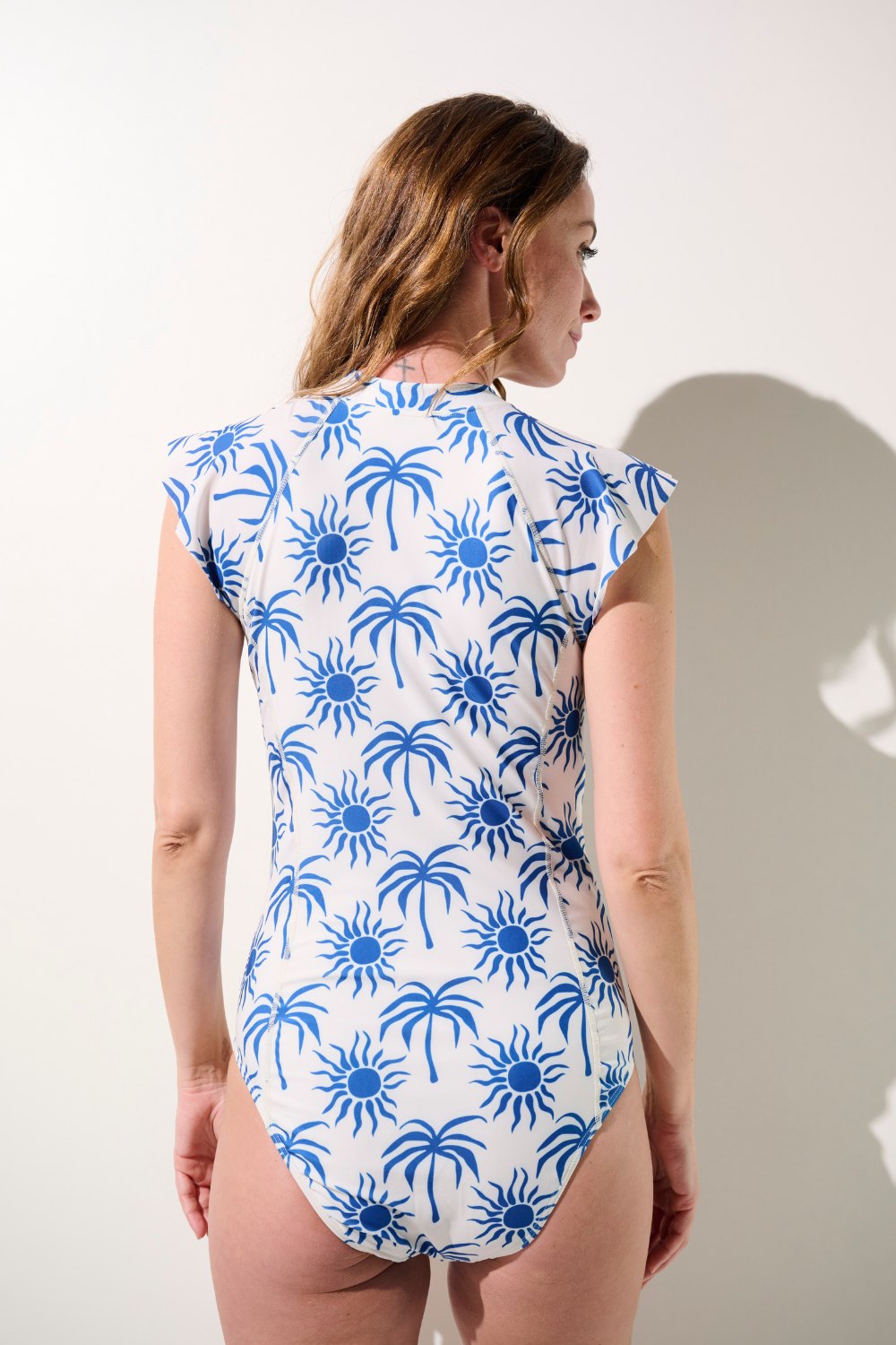 Maillot de bain anti-UV manches courtes - Pacific, tissu léger UPF 50+, motif soleil bleu, pour femme.