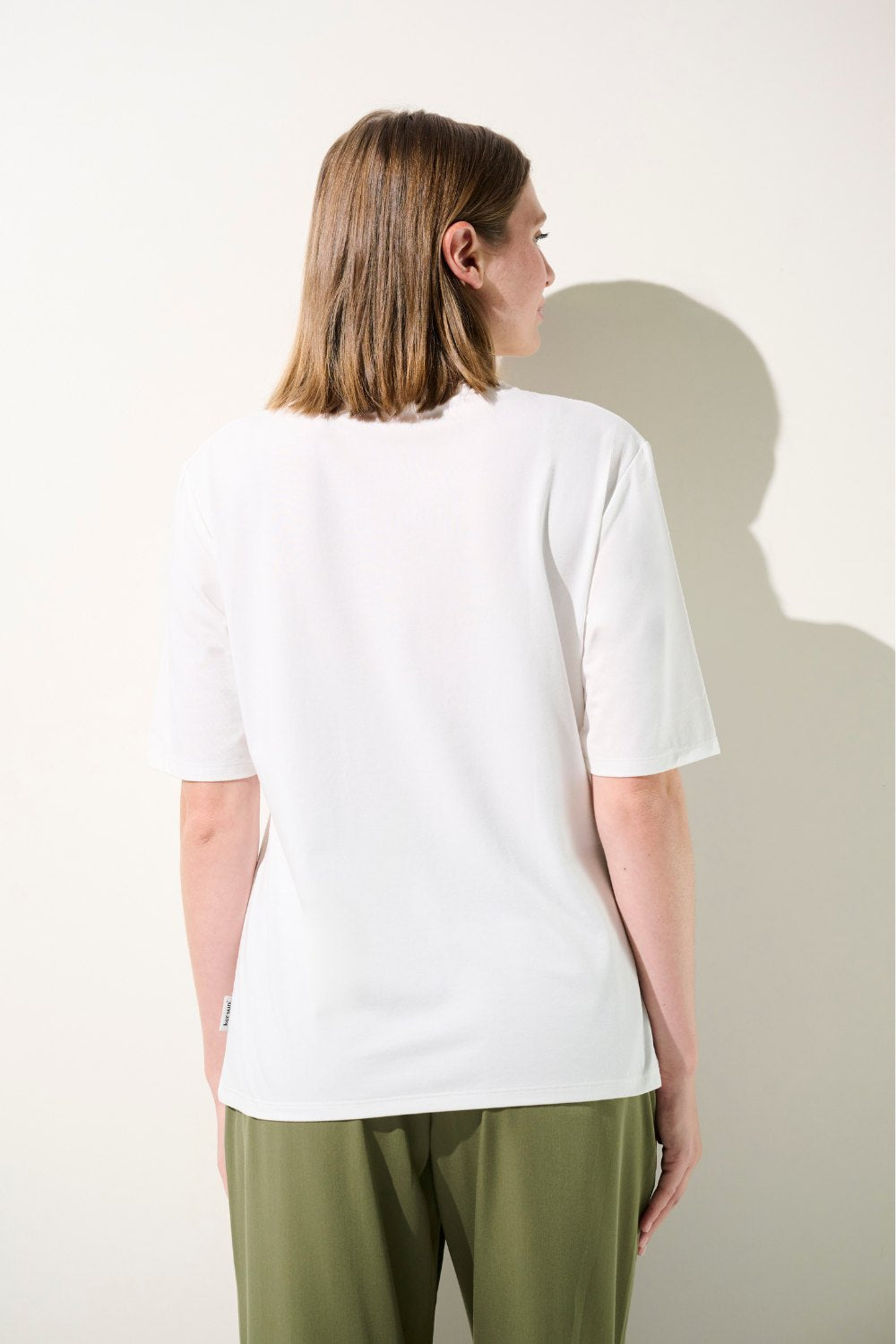 T-shirt anti-UV blanc UPF 50+ pour femme, léger et élégant, idéal pour les journées ensoleillées.