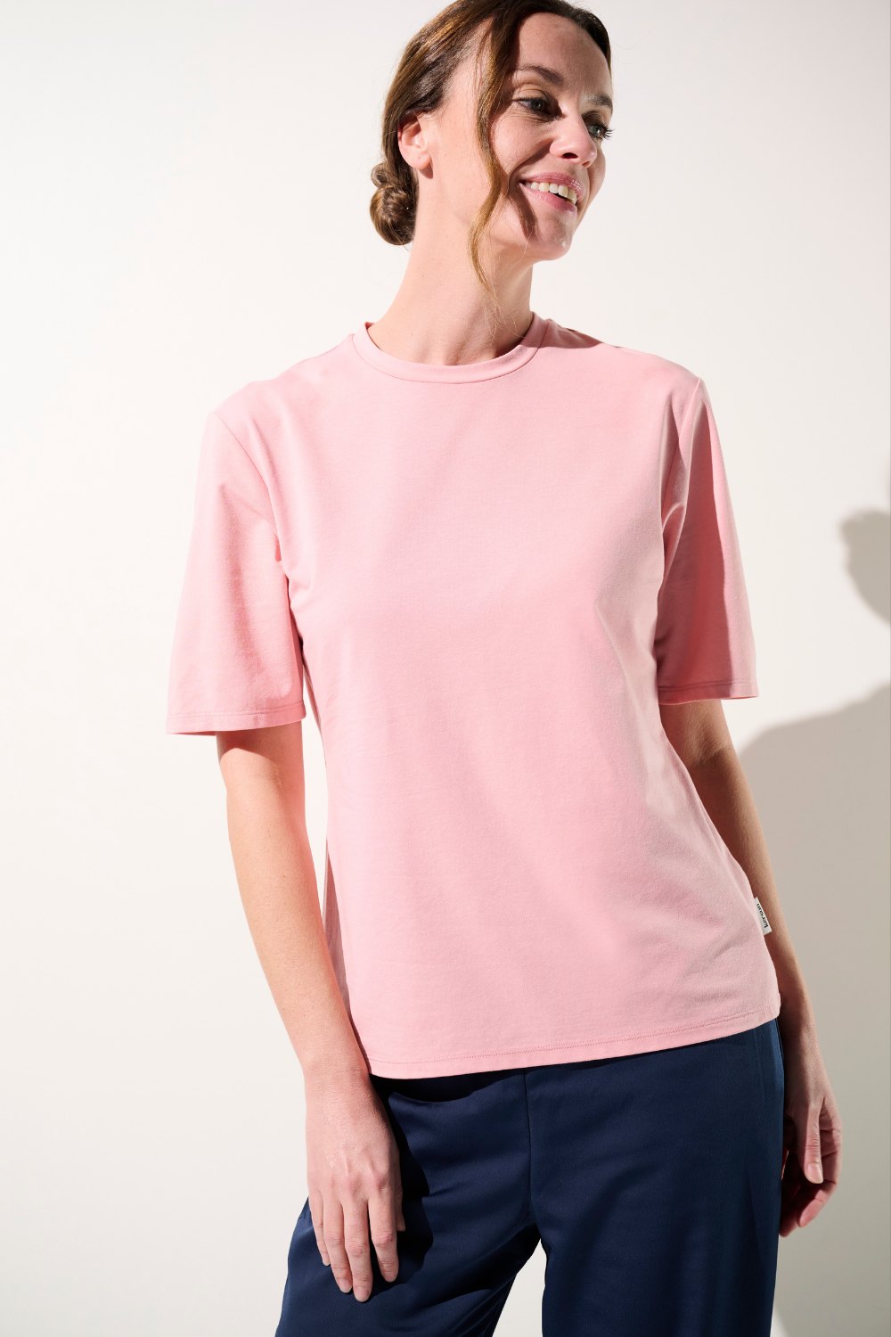 T-shirt anti-UV rose UPF 50+ pour femme, léger et élégant, parfait pour des moments de détente en extérieur.