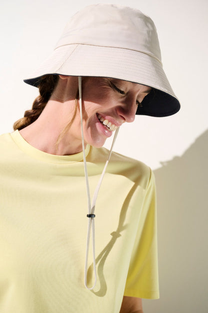 Bob anti-UV - Faro beige, léger et pratique, porté par une femme souriante pour protection solaire.