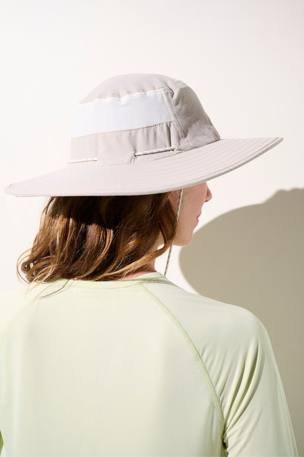 Chapeau anti-UV - Oasis beige UPF 50+ porté par une femme, idéal pour se protéger du soleil durant les activités extérieures.