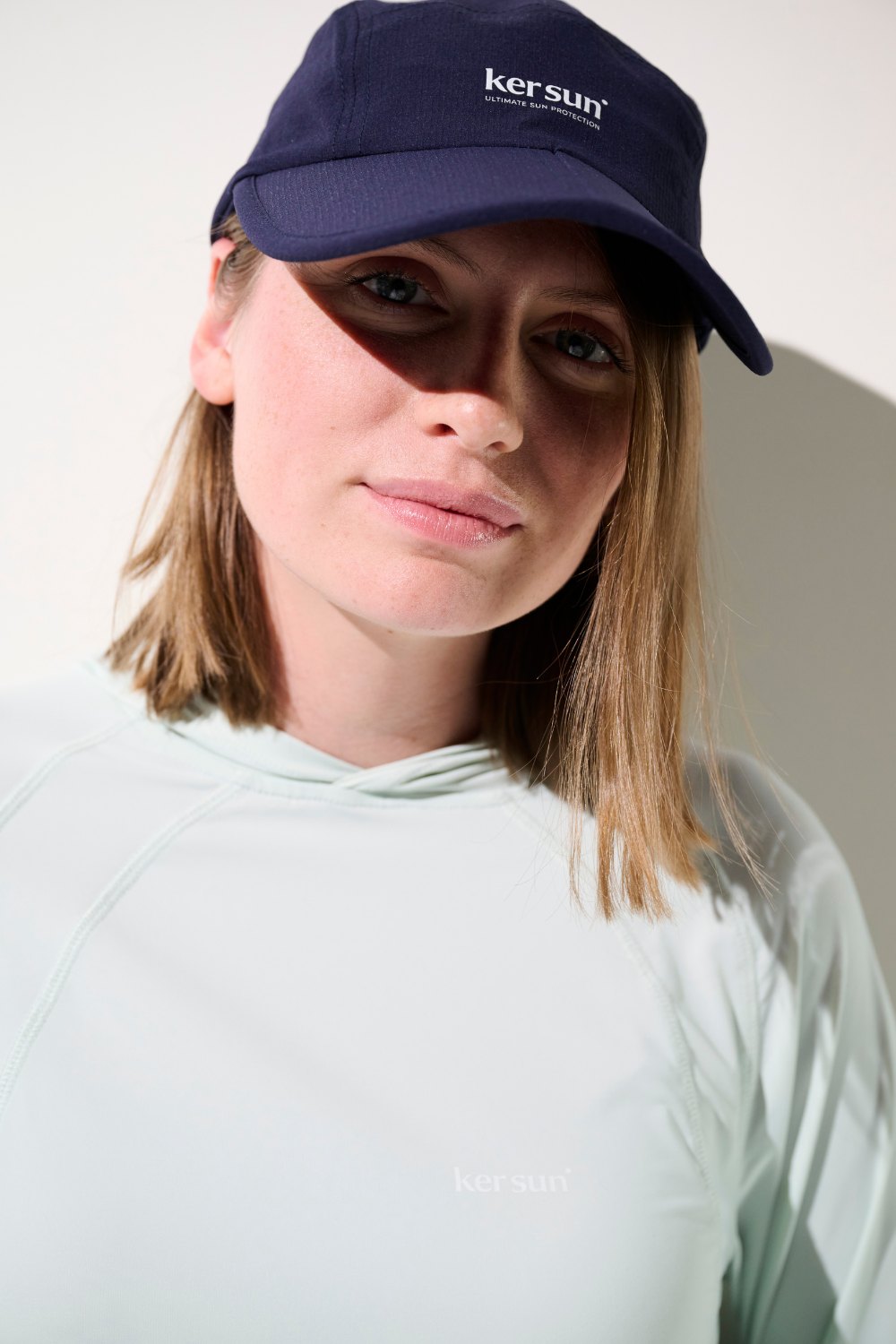 Casquette anti-UV - Sequoia de Ker Sun, coloris bleu marine, portée par une femme en tenue sportive légère.