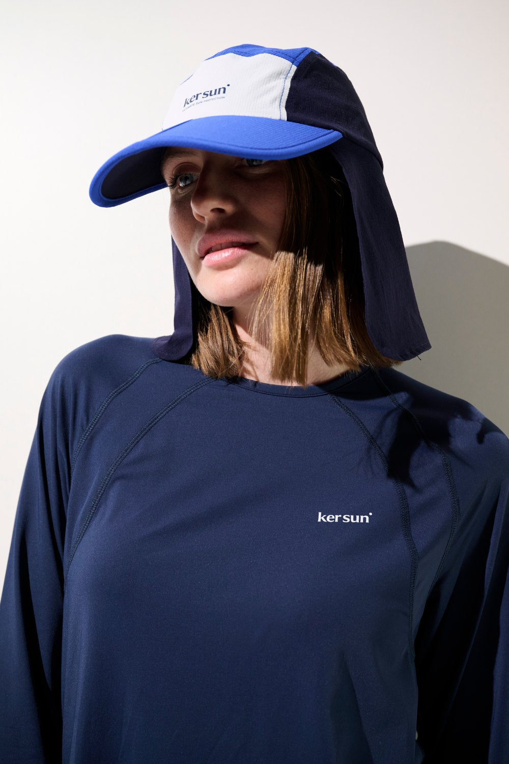 Casquette anti-UV Sequoia bleue UPF 50+, portée par une femme pour une protection solaire sportive.