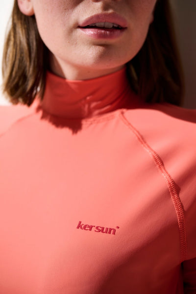 T-shirt de bain anti-UV - Malibu, femme portant un top en lycra rose UPF 50+ pour protection solaire.